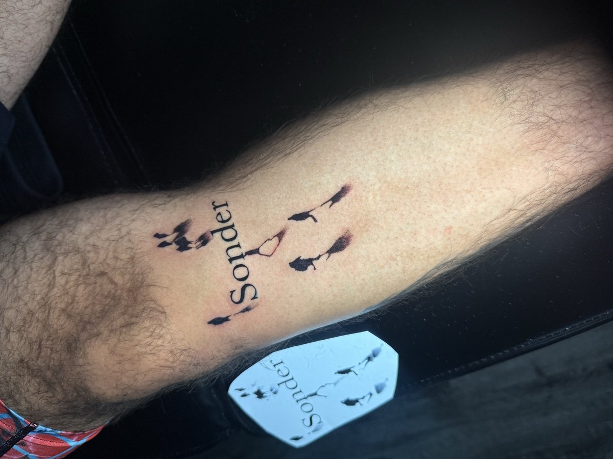 Small script and symbol tattoo on an inner forearm.